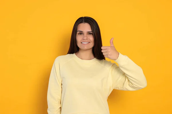 Young Woman Showing Thumb Orange Background — Zdjęcie stockowe