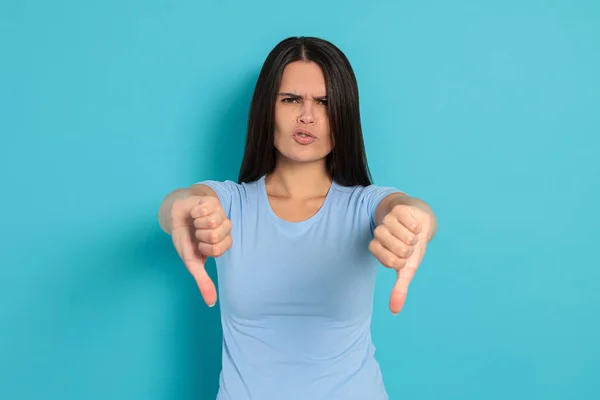Young Woman Showing Thumbs Light Blue Background — Stockfoto