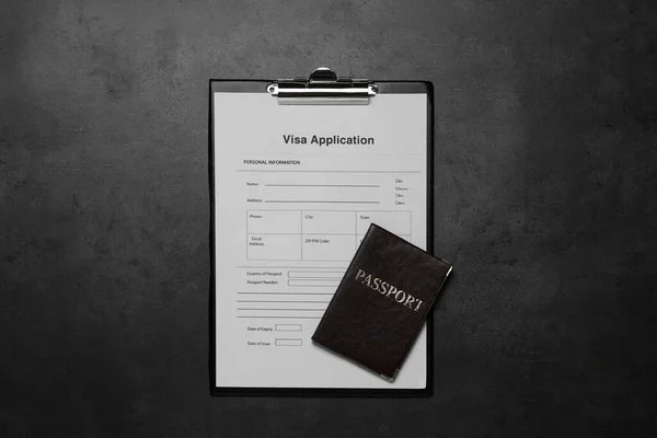 Visa application form for immigration and passport on grey table, top view