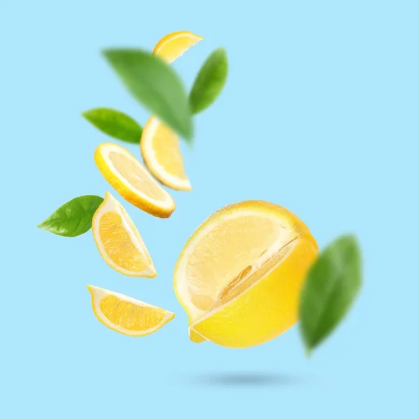 Fresh Ripe Lemons Green Leaves Falling Light Blue Background — Foto de Stock