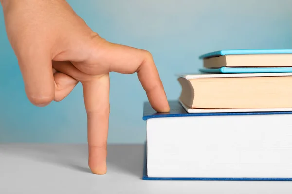 Woman Imitating Stepping Books Her Fingers Light Blue Background Closeup — Foto de Stock