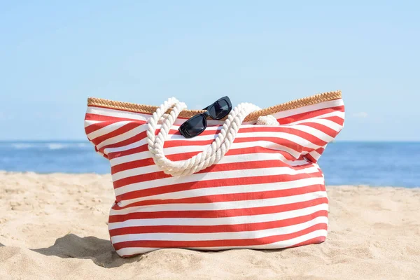 Stylish Striped Bag Sunglasses Sandy Beach Sea —  Fotos de Stock