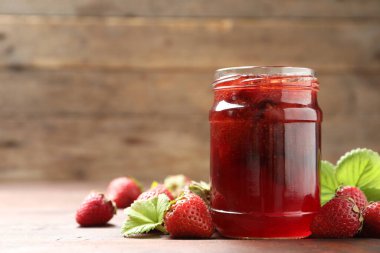 Lezzetli turşulu çilek reçeli ve ahşap masada taze böğürtlen. Metin için boşluk