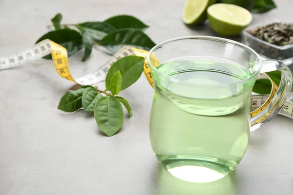 Herbal diet tea, lime and measuring tape on light table