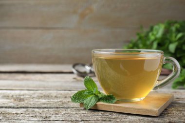 Tahta masada bir fincan sıcak aromatik nane çayı. Metin için boşluk