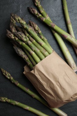 Fresh raw asparagus on black table, flat lay