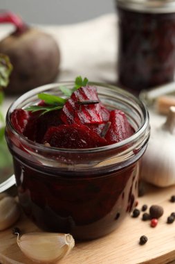 Delicious pickled beets and spices on wooden board