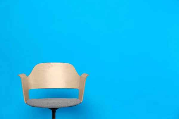 Comfortable office chair on light blue background, space for text