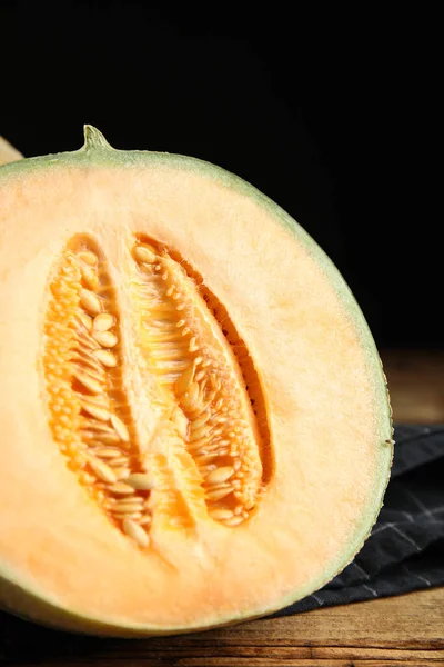 Half of fresh melon on wooden table, closeup