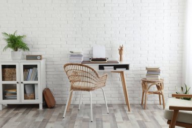 Comfortable writer's workplace interior with typewriter on desk near white brick wall