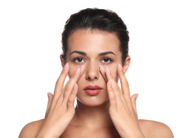 Woman applying cream under eyes on white background. Skin care