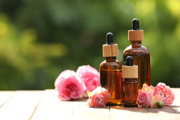 Bottles Rose Essential Oil Flowers Wooden Table Outdoors Space Text — Stockfoto
