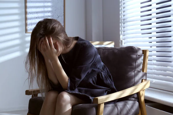 若い女性が屋内で泣いている 家庭内暴力の概念 — ストック写真