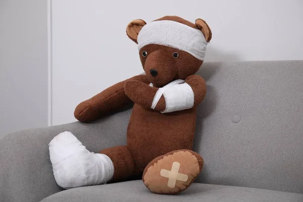 Toy Bear Bandages Sitting Sofa Light Wall —  Fotos de Stock