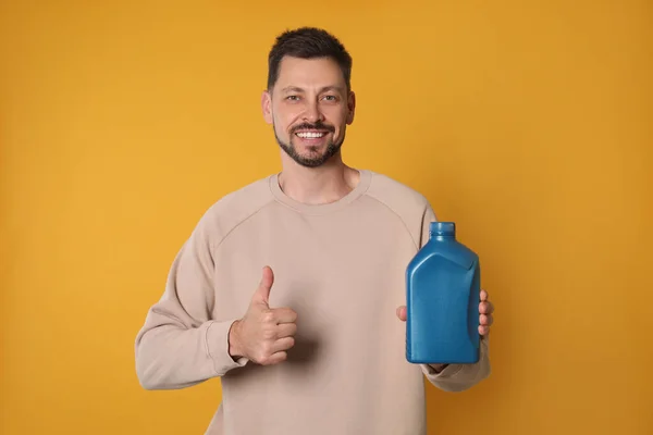 Man Holding Blue Container Motor Oil Showing Thumbs Orange Background — 스톡 사진