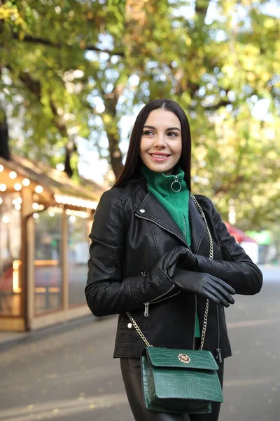 街の通りに革の手袋とスタイリッシュな緑のバッグを持つ美しい若い女性 — ストック写真