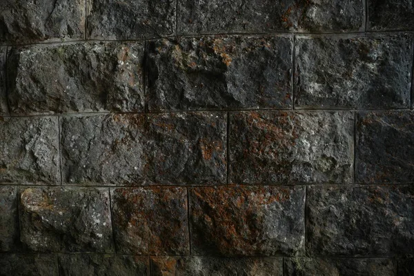 Texture of dark stone wall as background, closeup