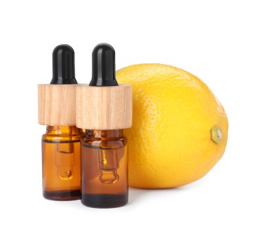 Bottles of citrus essential oil and fresh lemon isolated on white