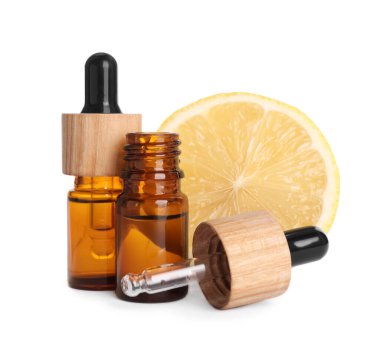 Bottles of citrus essential oil and fresh lemon isolated on white