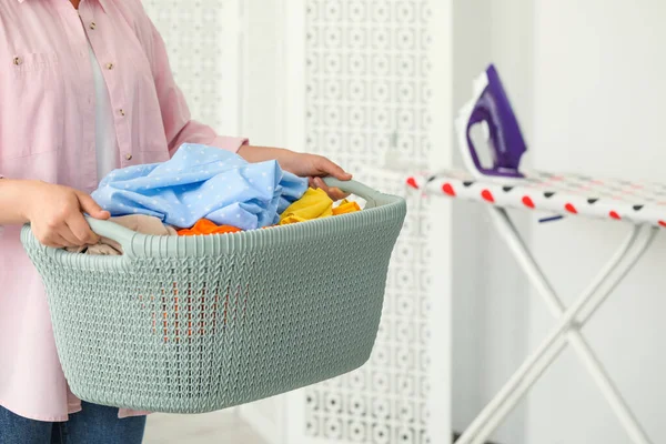 Woman with basket full of clean laundry indoors, closeup