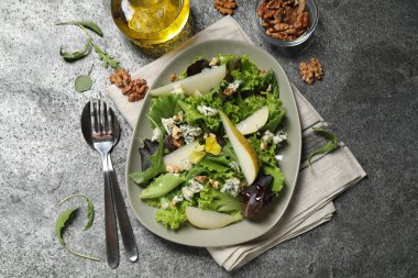 Fresh salad with pear served on grey table, flat lay