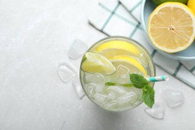 Lezzetli limonatanın düz kompozisyonu soda ve nane şekerli açık gri masa, yazı için yer. Taze yaz kokteyli.