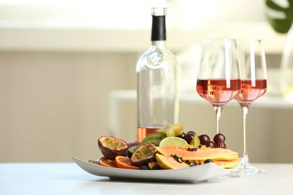 Ízletes Egzotikus Gyümölcsök Bor Fehér Asztalon — Stock Fotó