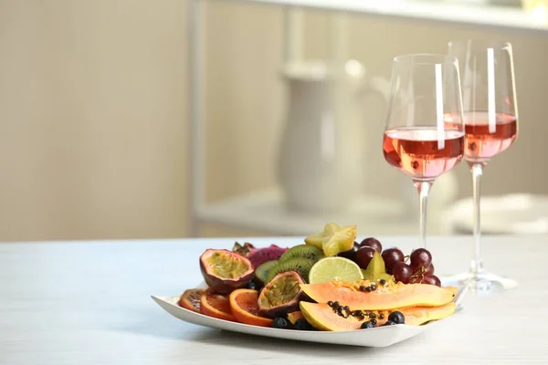 Ízletes Egzotikus Gyümölcsök Bor Fehér Asztalon — Stock Fotó