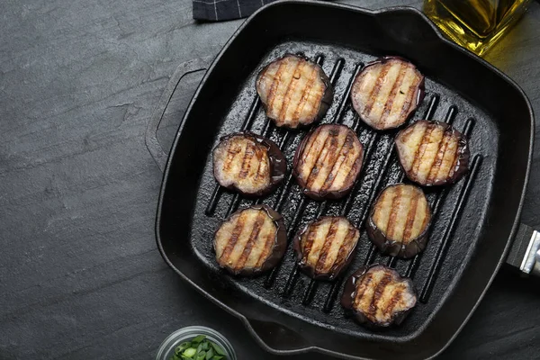 Siyah masada tavada ızgara patlıcan dilimleri. Metin için boşluk