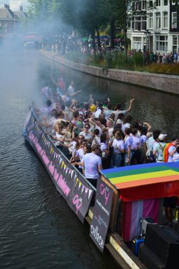 AMSTERDAM, NETHERLANDS - AUGUST 06, 2022: Many people in boat at LGBT pride parade on river