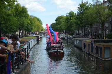 AMSTERDAM, NETHERLANDS - AUGUST 06, 2022: Many people in boats at LGBT pride parade on river