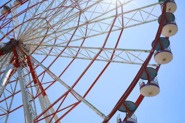 Beautiful large Ferris wheel against blue sky, low angle view