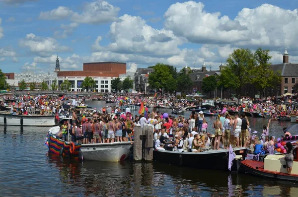 AMSTERDAM, NETHERLANDS - AUGUST 06, 2022: Many people in boats at LGBT pride parade on river