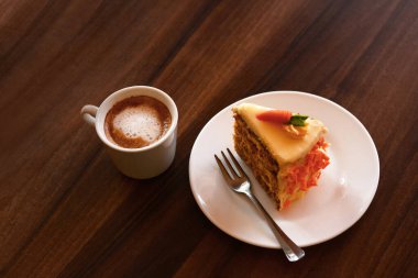 Delicious cake and cup of hot coffee on wooden table