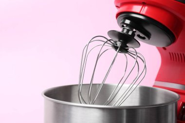 Modern red stand mixer on pink background, closeup