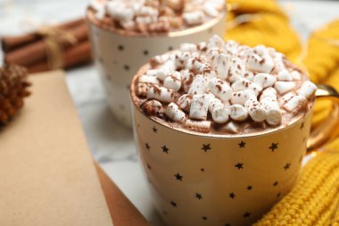 Bir fincan lezzetli sıcak kakao, beyaz masada marşmelov, yakın plan.