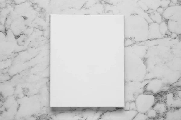 Blank canvas on white marble background, top view. Space for design