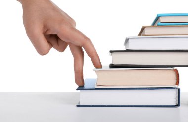 Woman imitating stepping up on books with her fingers against white background, closeup