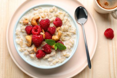 Flat lay composition with tasty oatmeal porridge on wooden table. Healthy meal
