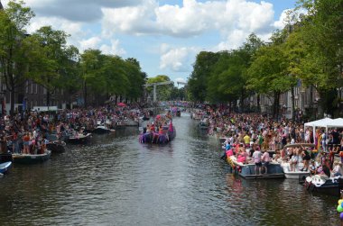 AMSTERDAM, NETHERLANDS - AUGUST 06, 2022: Many people in boats at LGBT pride parade on river