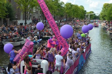 AMSTERDAM, NETHERLANDS - AUGUST 06, 2022: Many people in boats at LGBT pride parade on river