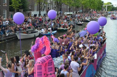 AMSTERDAM, NETHERLANDS - AUGUST 06, 2022: Many people in boats at LGBT pride parade on river