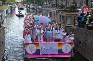 AMSTERDAM, NETHERLANDS - AUGUST 06, 2022: Many people in boats at LGBT pride parade on river