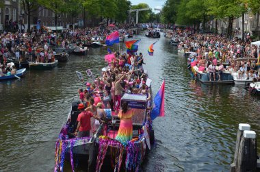 AMSTERDAM, NETHERLANDS - AUGUST 06, 2022: Many people in boats at LGBT pride parade on river