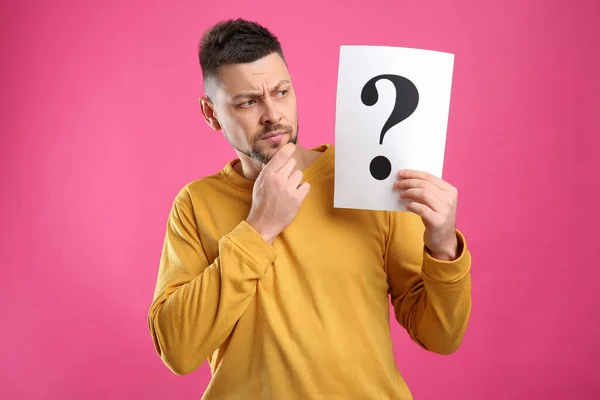 Emotional Man Holding Paper Question Mark Pink Background — Stock fotografie