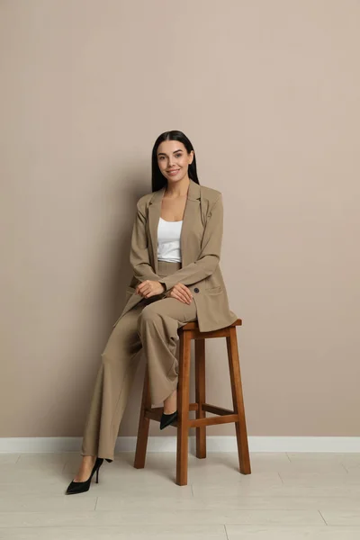 Piękna Młoda Bizneswoman Siedzi Stołku Przy Beżowej Ścianie — Zdjęcie stockowe