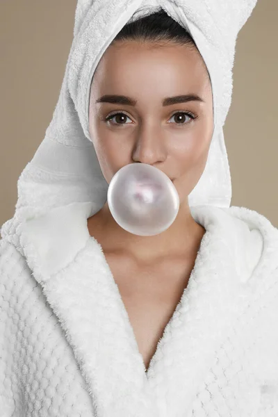 Jovem Mulher Roupão Soprando Chiclete Fundo Marrom — Fotografia de Stock