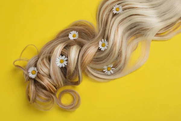 Κλειδαριά Από Υγιή Ξανθά Μαλλιά Λουλούδια Κίτρινο Φόντο Κορυφαία Άποψη — Φωτογραφία Αρχείου