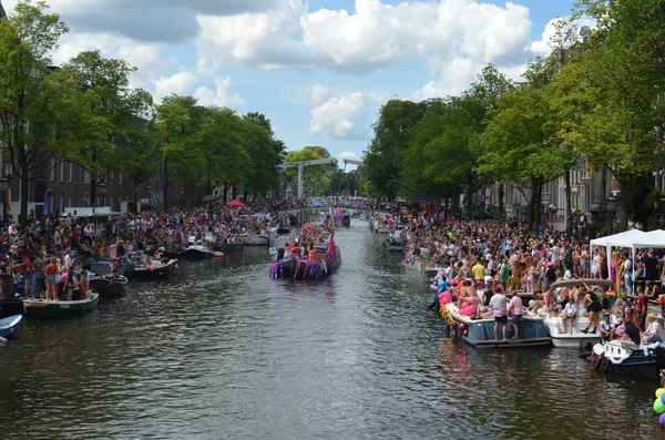 AMSTERDAM, NETHERLANDS - AUGUST 06, 2022: Many people in boats at LGBT pride parade on river