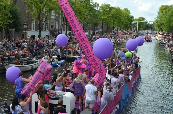 AMSTERDAM, NETHERLANDS - AUGUST 06, 2022: Many people in boats at LGBT pride parade on river